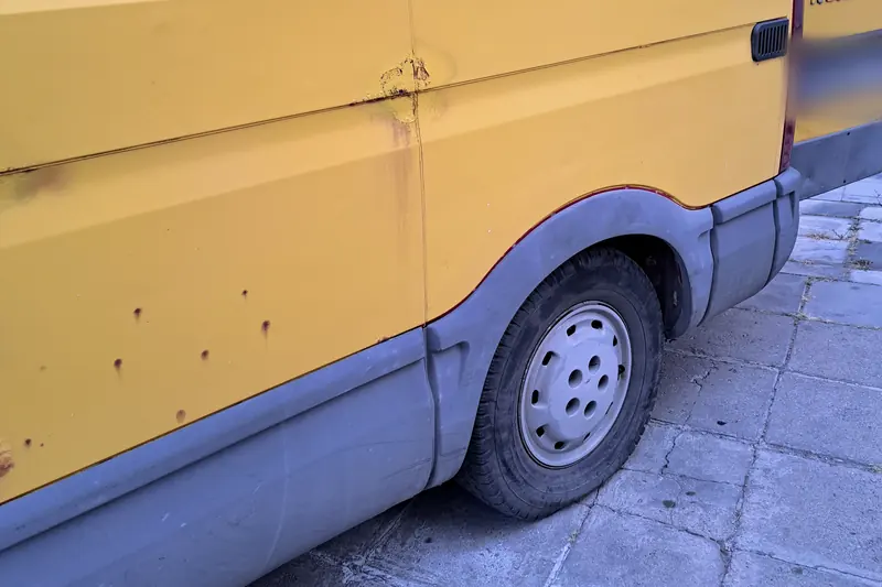 Жълт товарен бус Iveco Daily отстрани, паркиран до жилищна сграда